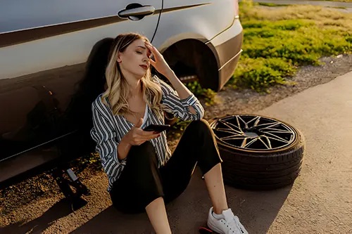 Image of a woman with a flat tire.